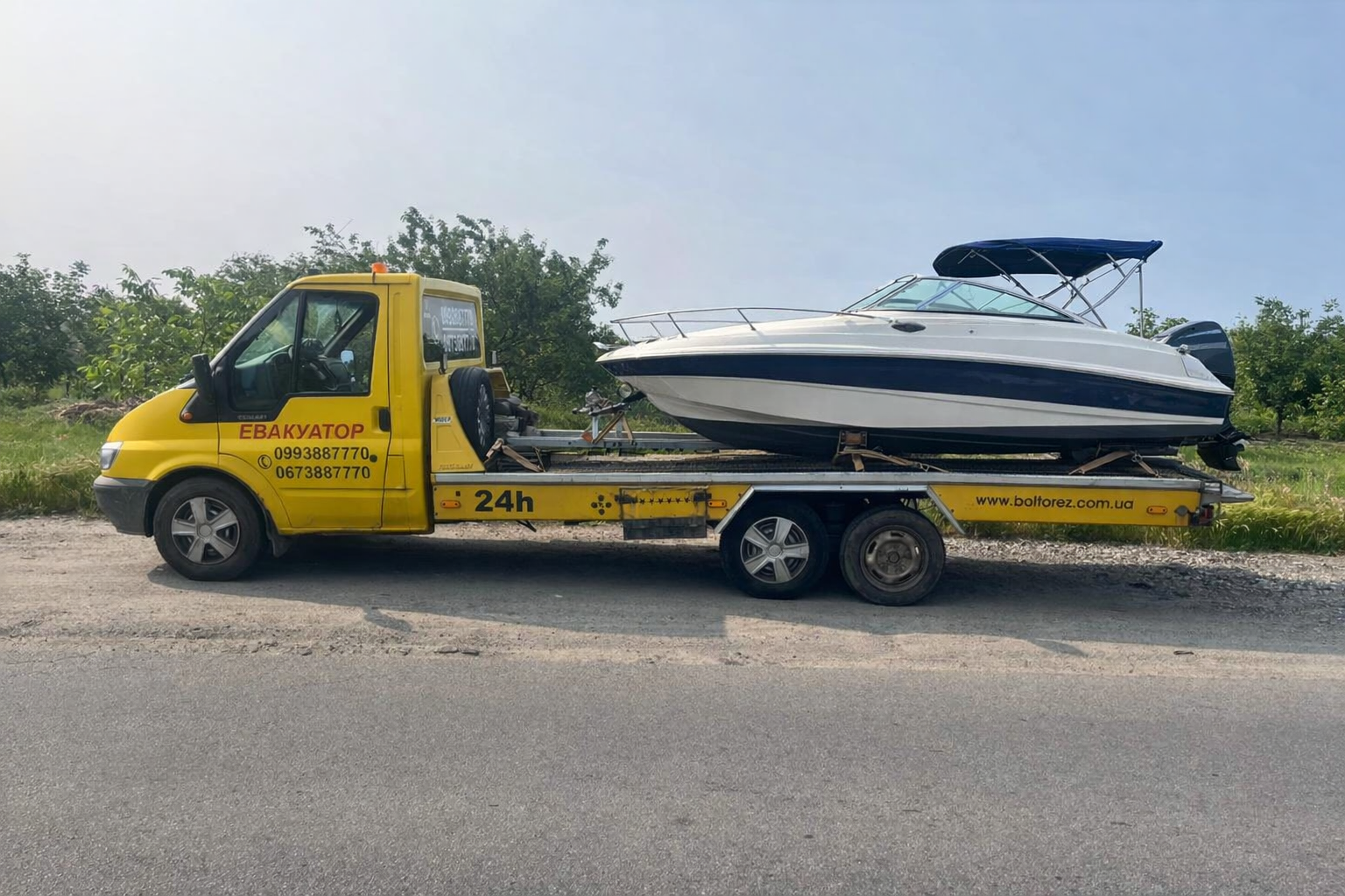 Евакуатор з моторним човном на платформі